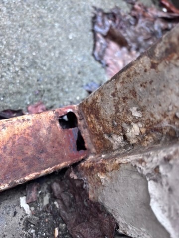 Nærbilde av gjennomrustet stålkarm i underkant av den gamle branndøren