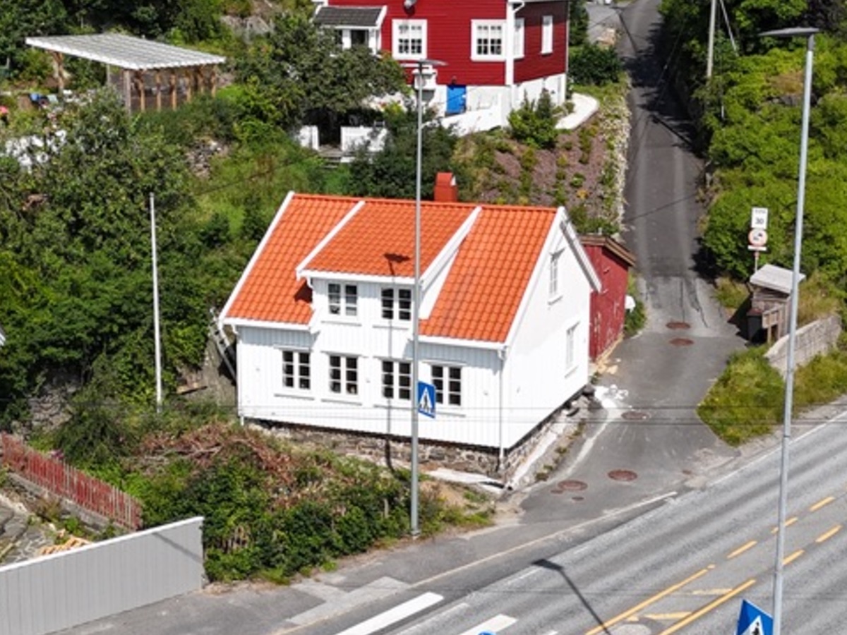 Samme trehus etter totalrenovering med hvit kledning og nytt tegltak