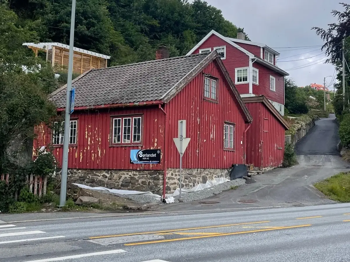 Sørlandshuset før totalrenovering, med slitt rød kledning